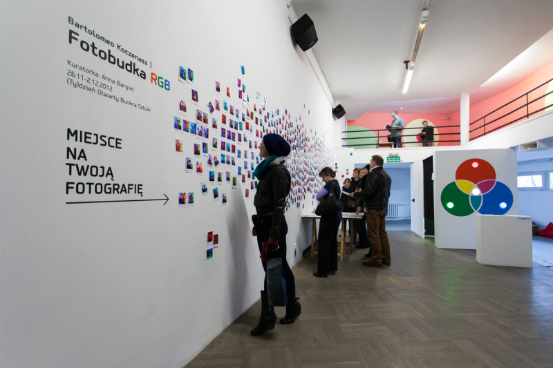 Interactive photo booth installation with RGB color diagram on white cubic structure, exhibition view at Bunkier Sztuki.